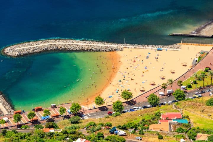 Golden sand and calm water at Machico Beach in Madeira